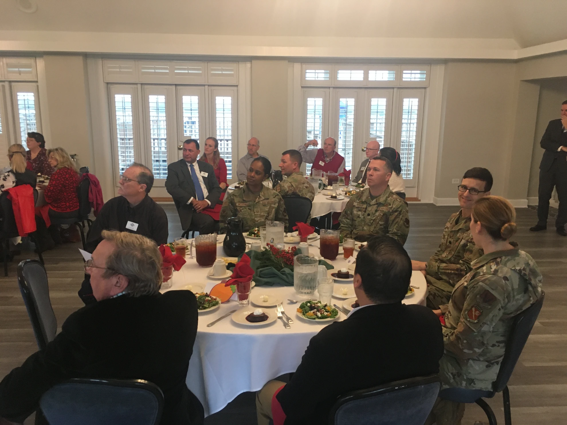 Wide shot of luncheon with military and civilian attendees at round tables