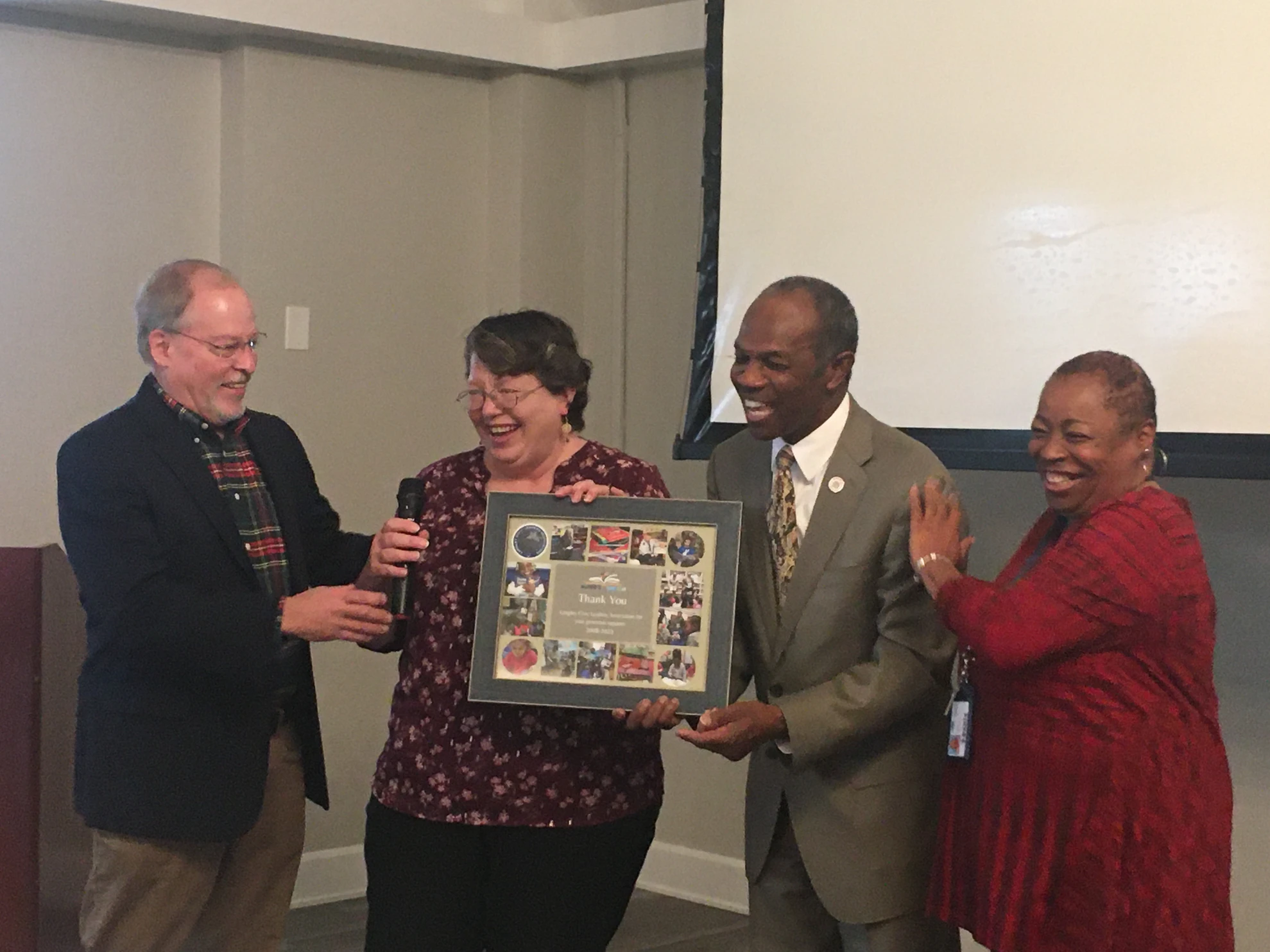 Group presenting Thank You photo frame plaque with smiles