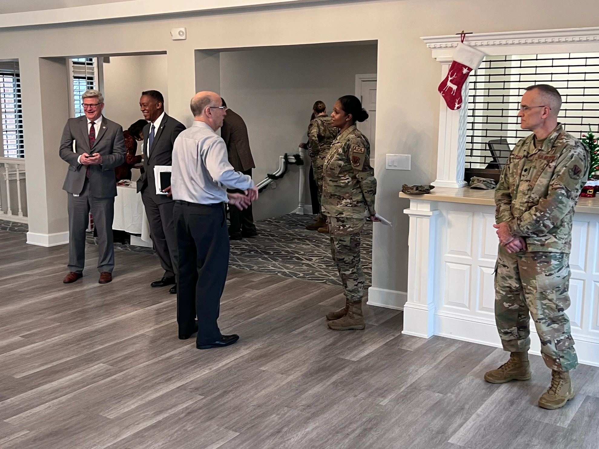 Military and civilian leaders in conversation near holiday decorations