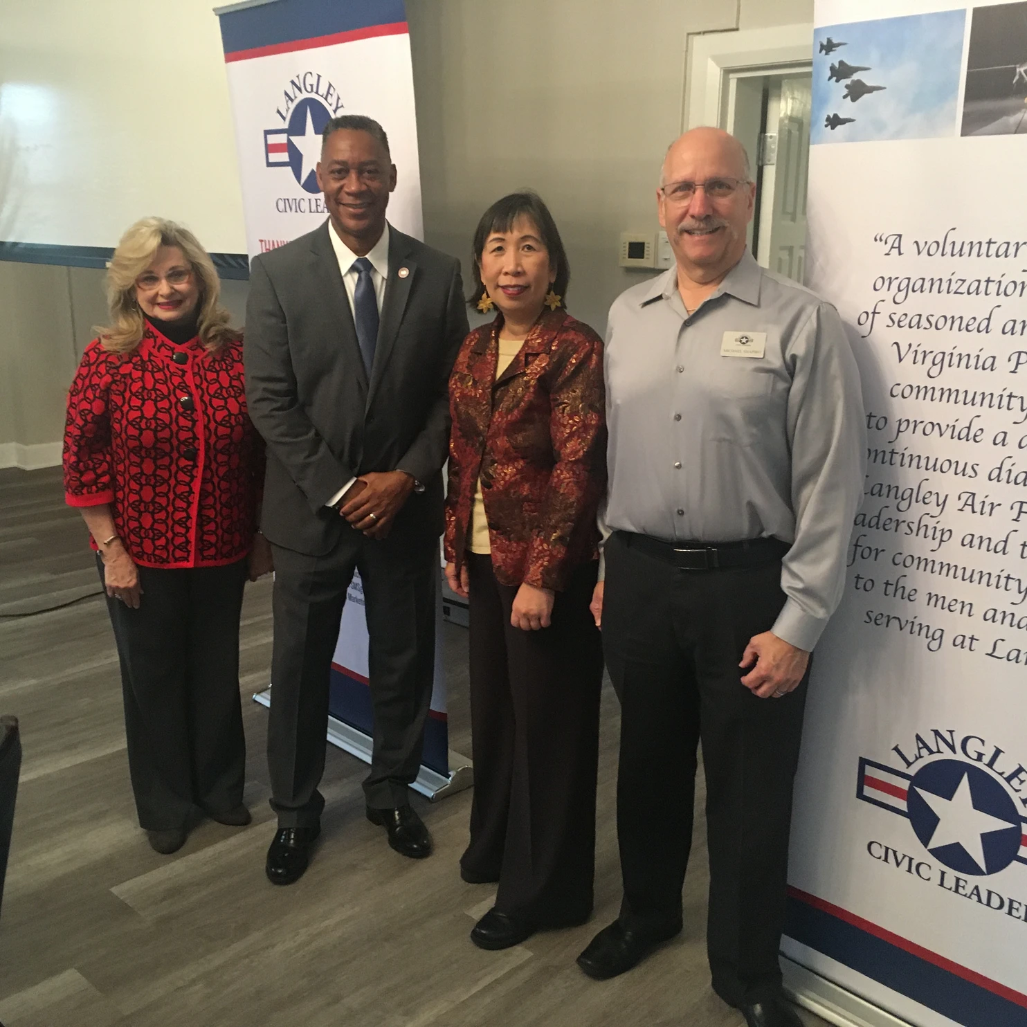 Four people posing with LCLA banners