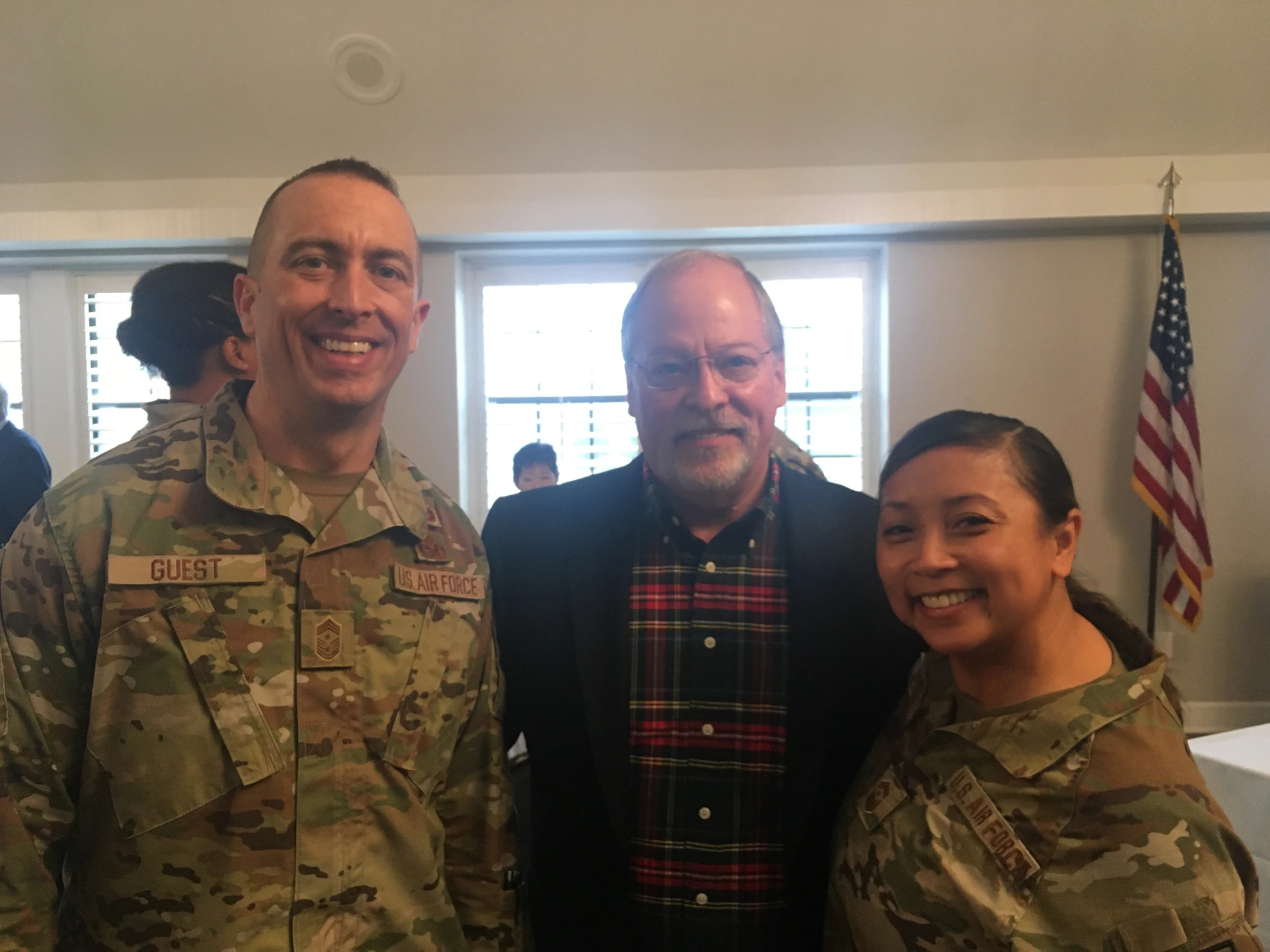 Three people posing - two Air Force members and civilian