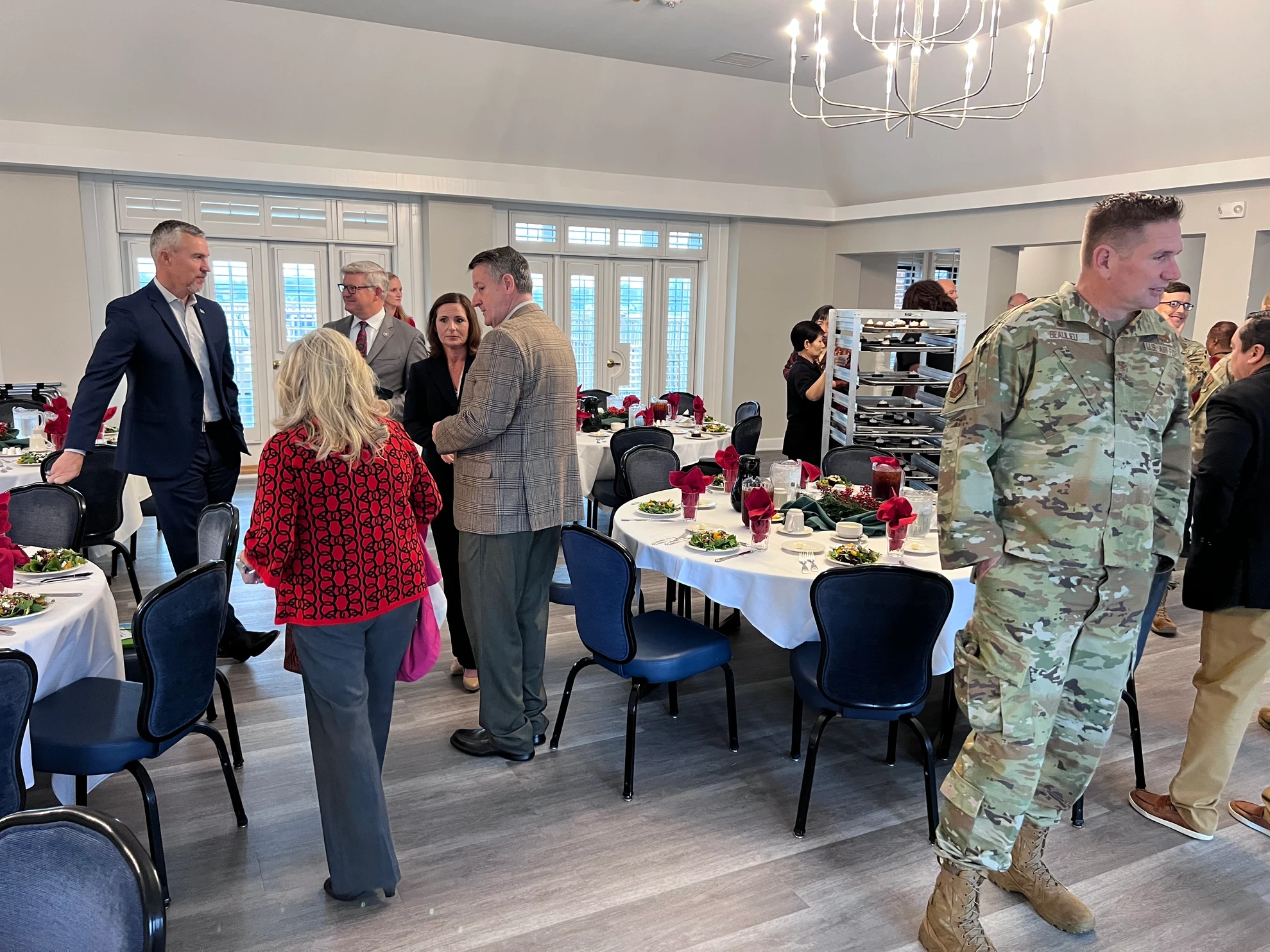 Attendees mingling in the event room with military and civilian members
