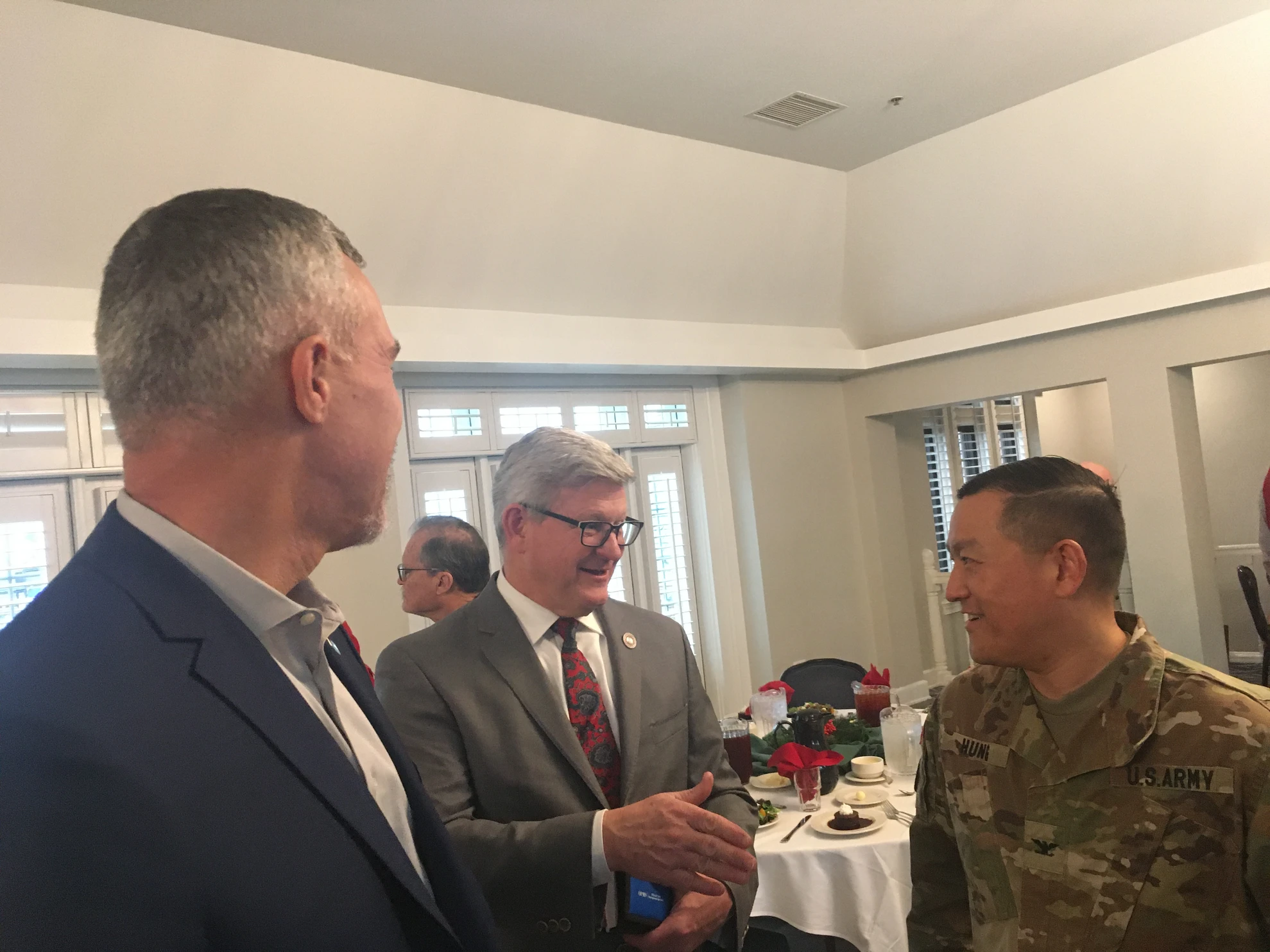 Three men in conversation - civilians and U.S. Army officer