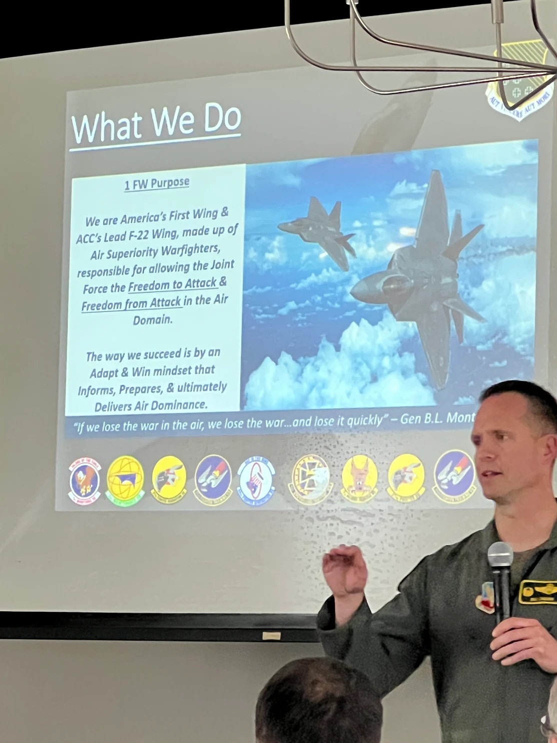 Military officer presenting about 1st Fighter Wing with F-22 Raptor slide